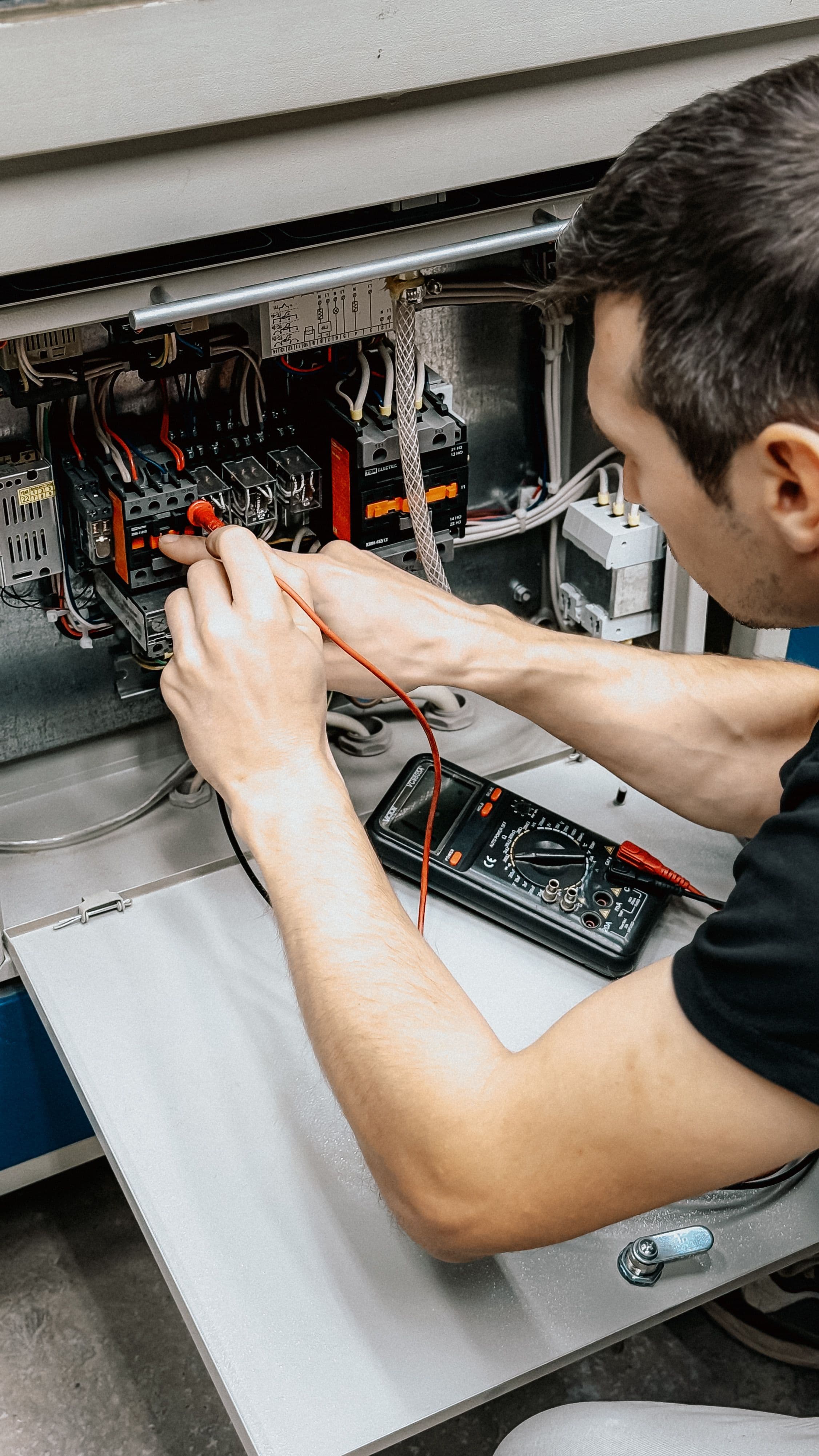 Technician running diagnostics with a multimeter